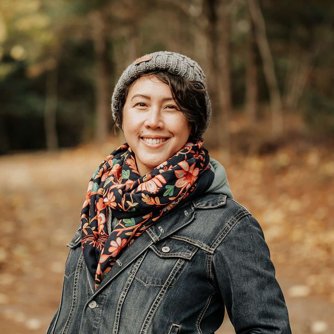 A photo of Diane Connors outside wearing a hat, scarf, and jean jacket.